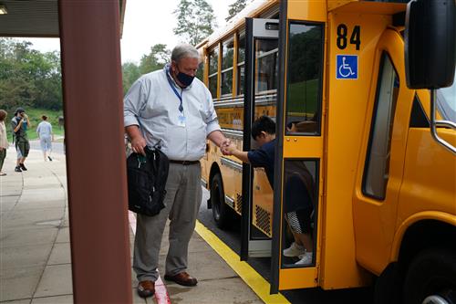 Helping a student off school bus at Mon Valley School
